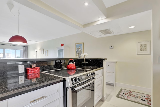 kitchen featuring stainless steel electric stove, light tile patterned floors, dark stone countertops, white cabinetry, and hanging light fixtures