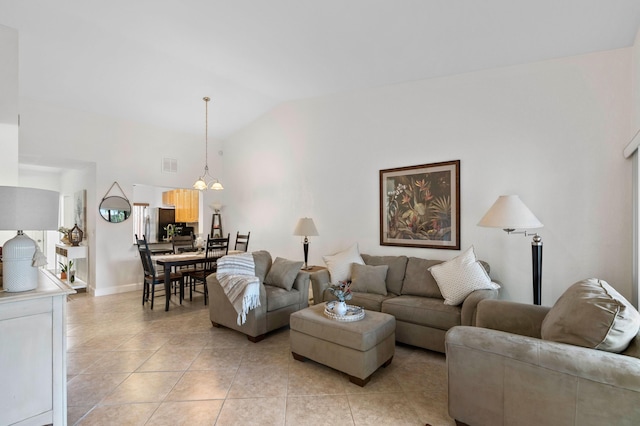 tiled living room featuring an inviting chandelier and vaulted ceiling