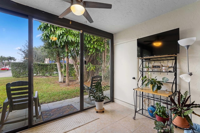 entryway with ceiling fan, light tile patterned floors, and a textured ceiling