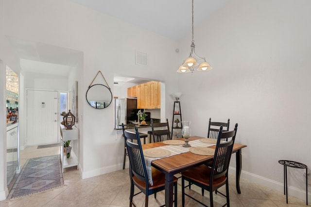 dining room with a chandelier, vaulted ceiling, and light tile patterned flooring