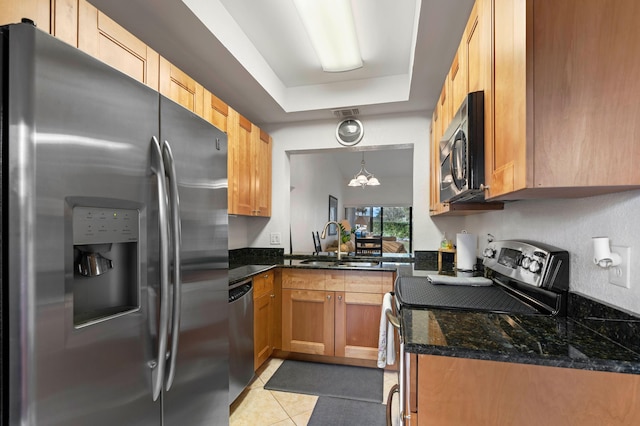 kitchen featuring pendant lighting, an inviting chandelier, a raised ceiling, light tile patterned floors, and stainless steel appliances