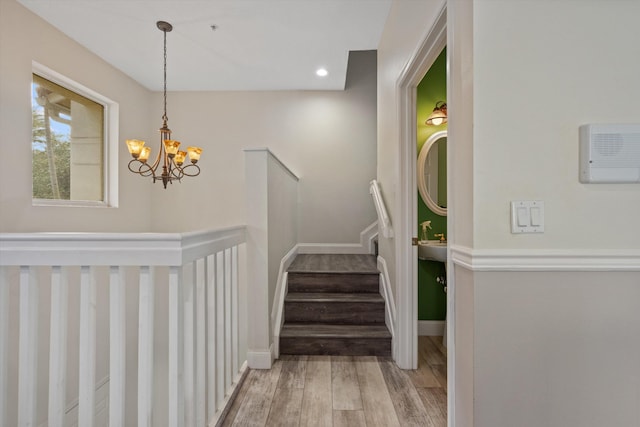 stairs with a chandelier and hardwood / wood-style flooring