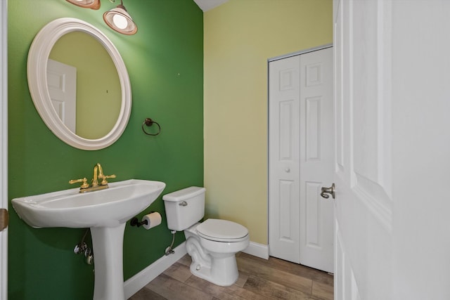 bathroom with hardwood / wood-style flooring and toilet