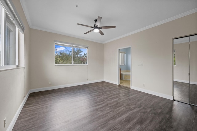 unfurnished bedroom with ensuite bath, ornamental molding, ceiling fan, dark hardwood / wood-style floors, and a closet