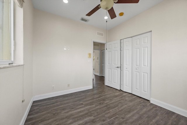 unfurnished bedroom featuring ceiling fan, dark hardwood / wood-style floors, and a closet