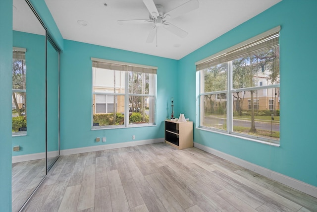 spare room with ceiling fan and light wood-type flooring