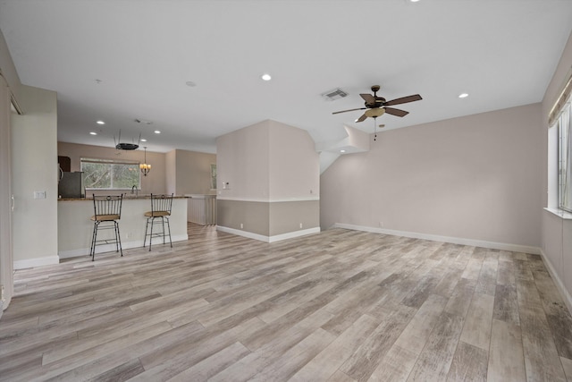 unfurnished living room with ceiling fan and light hardwood / wood-style floors