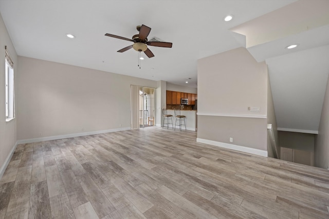 unfurnished living room featuring ceiling fan and light wood-type flooring