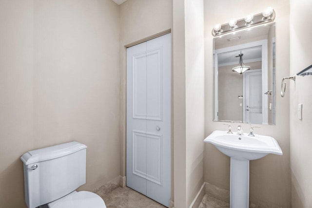 bathroom featuring toilet, tile patterned flooring, and crown molding