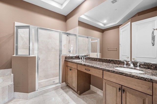 bathroom featuring tile patterned floors, vanity, a raised ceiling, and plus walk in shower