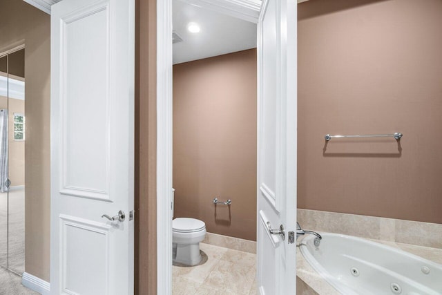 bathroom featuring tile patterned floors, tiled tub, and toilet