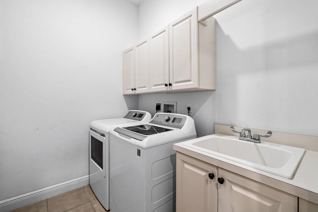 laundry area featuring light tile patterned flooring, cabinets, sink, and washer and dryer