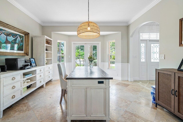 kitchen with white cabinets, hanging light fixtures, crown molding, and a kitchen island