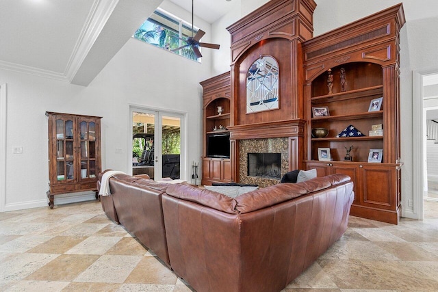 living room featuring a high end fireplace, french doors, built in shelves, ceiling fan, and crown molding