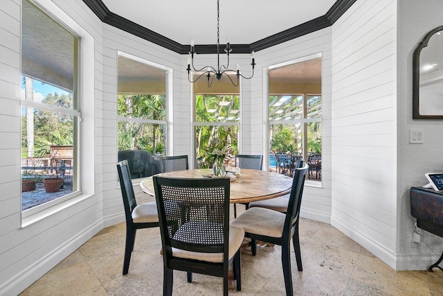 dining space featuring a wealth of natural light, crown molding, and a chandelier