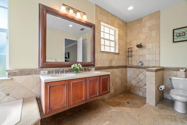 full bathroom featuring vanity, tile walls, and shower with separate bathtub