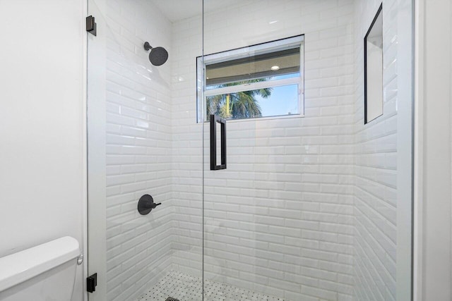 bathroom with toilet and a shower with shower door