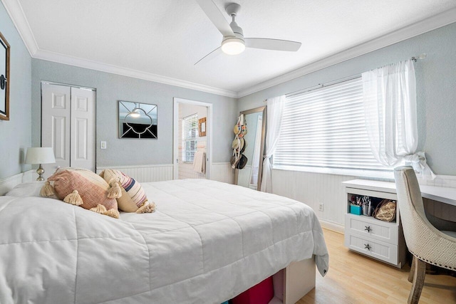 bedroom with a closet, ceiling fan, crown molding, and light wood-type flooring