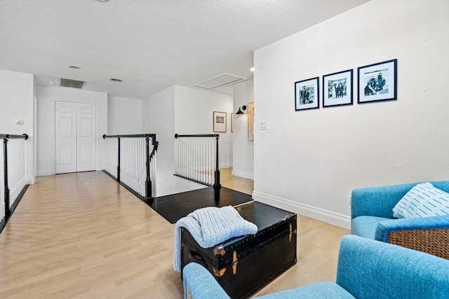 sitting room with a textured ceiling and light hardwood / wood-style flooring