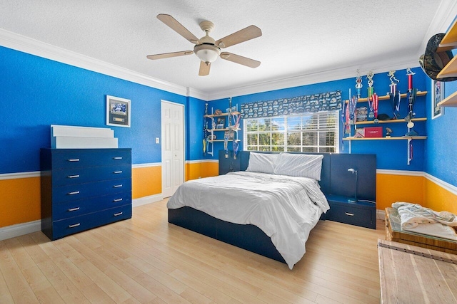 bedroom with a textured ceiling, light wood-type flooring, ceiling fan, and crown molding