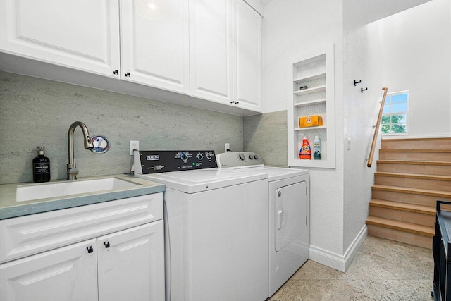 laundry room featuring washing machine and dryer, sink, light tile patterned flooring, and cabinets