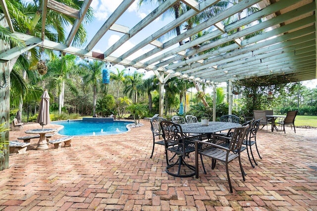 view of pool with pool water feature, a pergola, and a patio