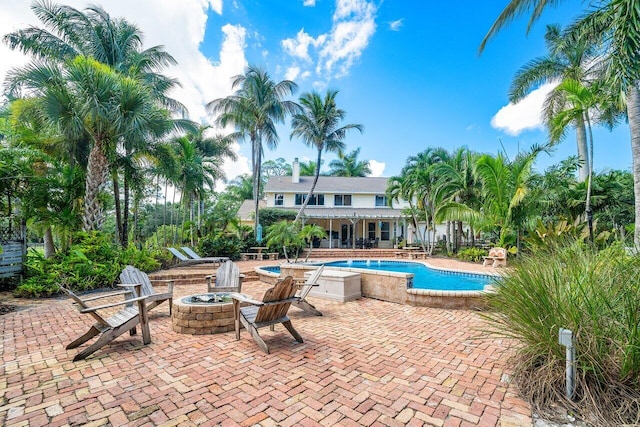 view of pool with an outdoor fire pit and a patio area