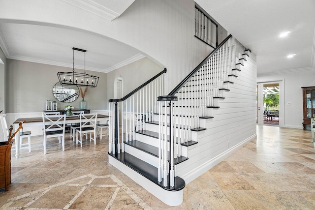 stairs featuring crown molding and a notable chandelier