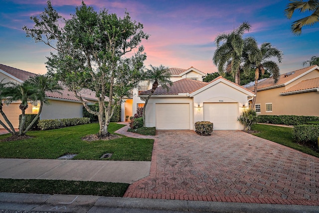 mediterranean / spanish house with a yard and a garage