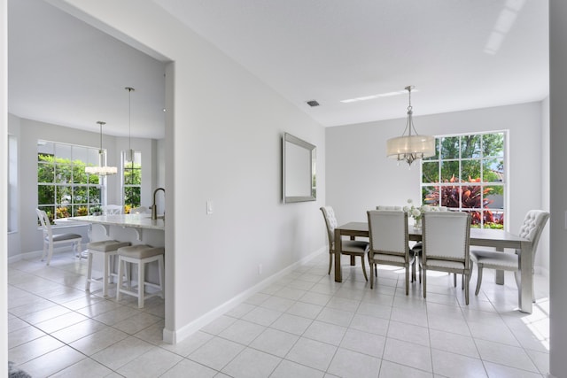 tiled dining space with an inviting chandelier and sink