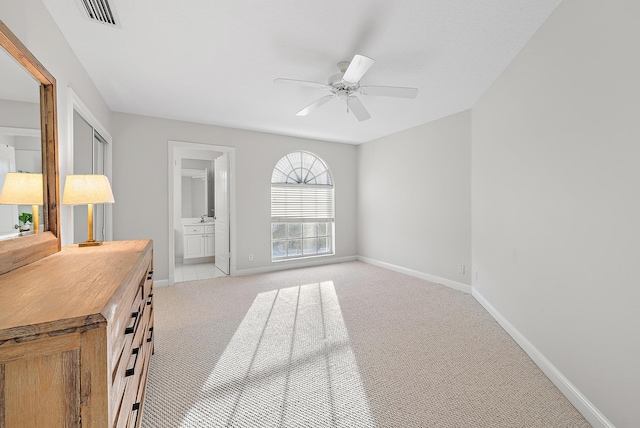 interior space with connected bathroom, ceiling fan, and light colored carpet