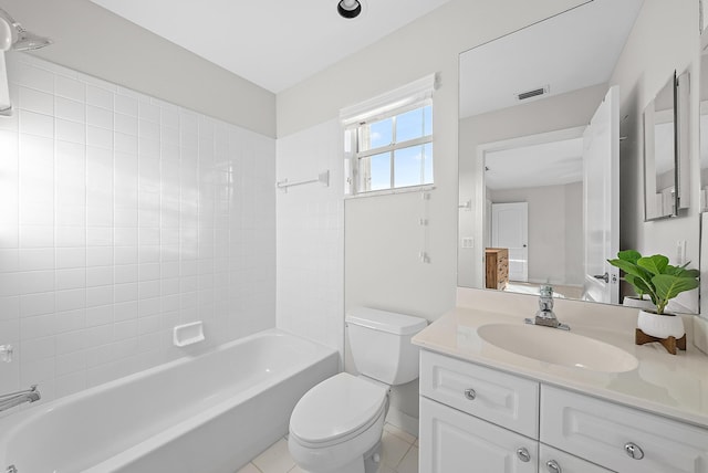 full bathroom featuring tile patterned floors, tiled shower / bath, vanity, and toilet