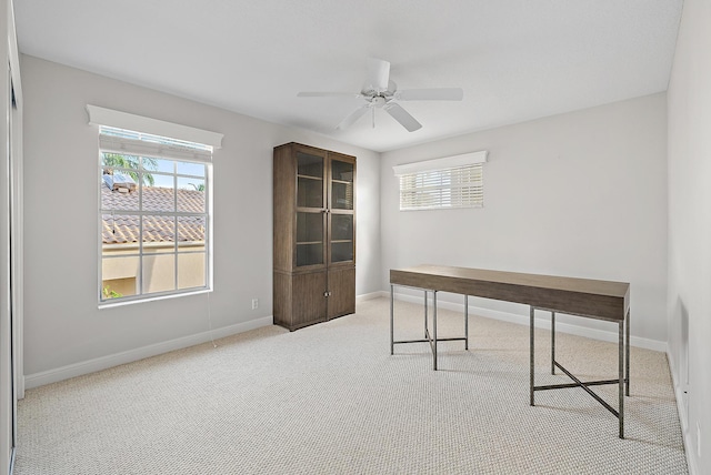 carpeted office space featuring ceiling fan and a healthy amount of sunlight