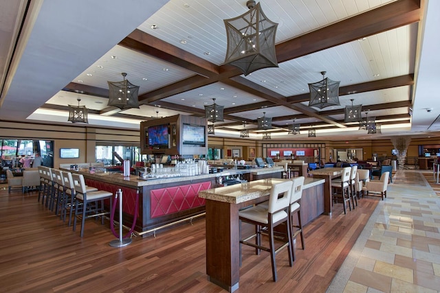 kitchen with a large island, beamed ceiling, a kitchen bar, and dark wood-type flooring