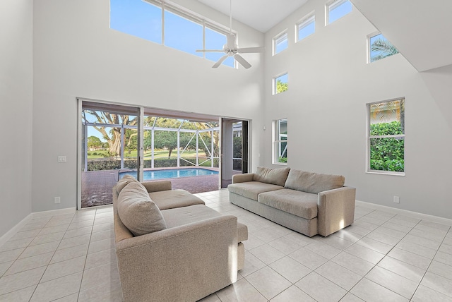 living room with a high ceiling, ceiling fan, and light tile patterned flooring