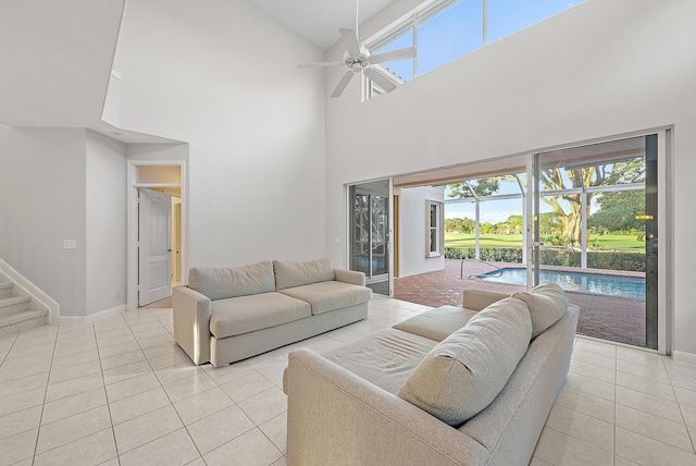 living room with ceiling fan, high vaulted ceiling, and light tile patterned flooring