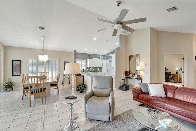 living room featuring lofted ceiling, light tile patterned floors, and ceiling fan with notable chandelier