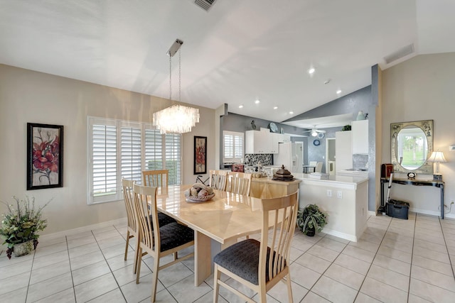 dining space with a healthy amount of sunlight, lofted ceiling, and a notable chandelier