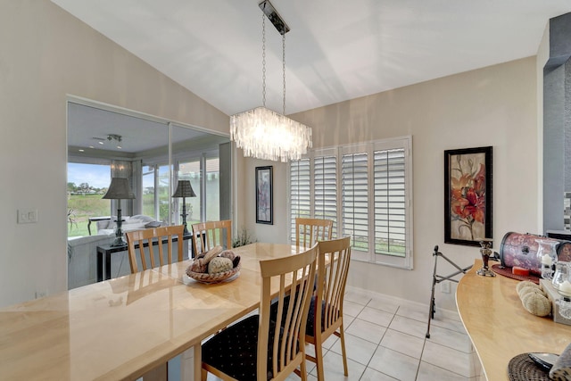 tiled dining room with lofted ceiling and a chandelier