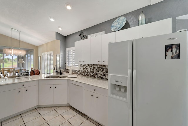 kitchen with white cabinets, lofted ceiling, white appliances, and sink