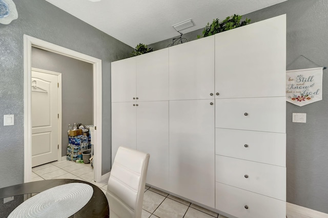 bathroom featuring tile patterned flooring and a textured ceiling