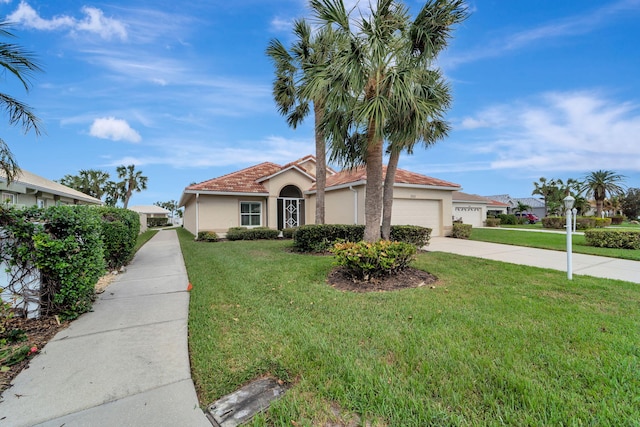 mediterranean / spanish-style house with a garage and a front lawn