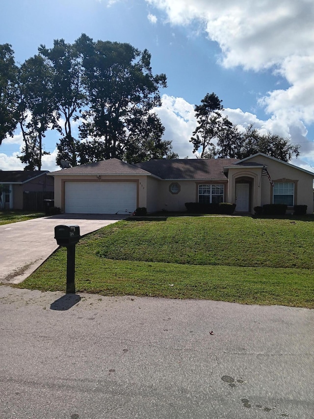 single story home with a garage and a front lawn