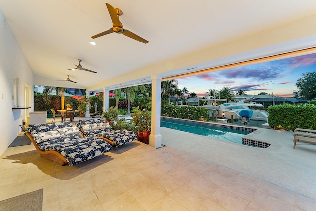 pool at dusk featuring a patio