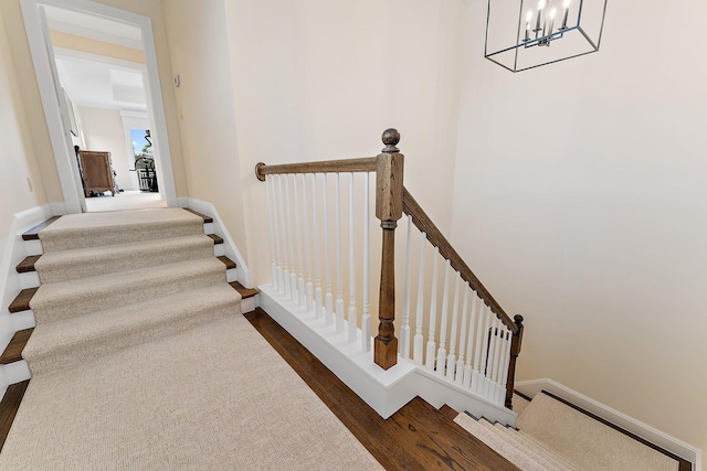 staircase with an inviting chandelier and hardwood / wood-style flooring