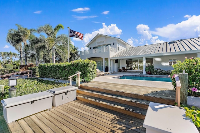 exterior space with a swimming pool side deck, a patio, and a balcony