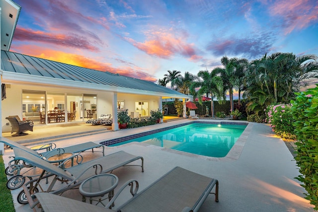 pool at dusk with a patio