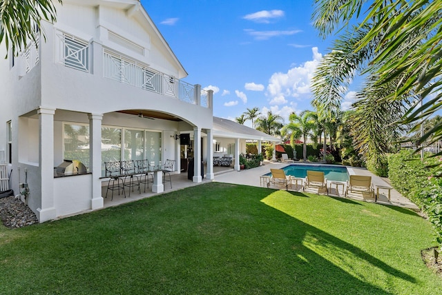 exterior space with an outdoor kitchen, a patio, and a lawn