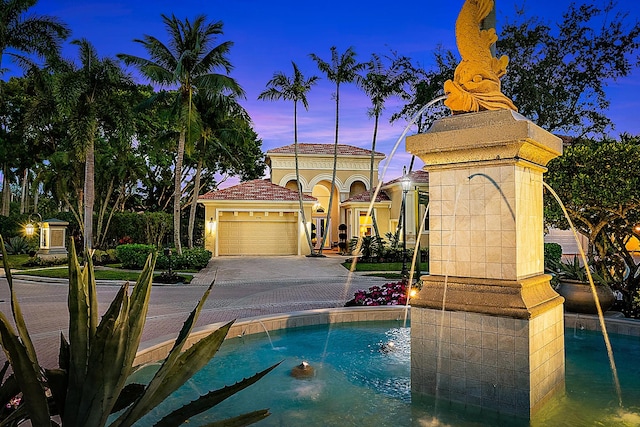 pool at dusk with pool water feature