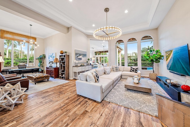 living room featuring a notable chandelier, a wealth of natural light, and light hardwood / wood-style flooring